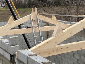 Mise en place des fermes lors de la pose d'une charpente traditionnelle pour une extension de maison par Amc charpente